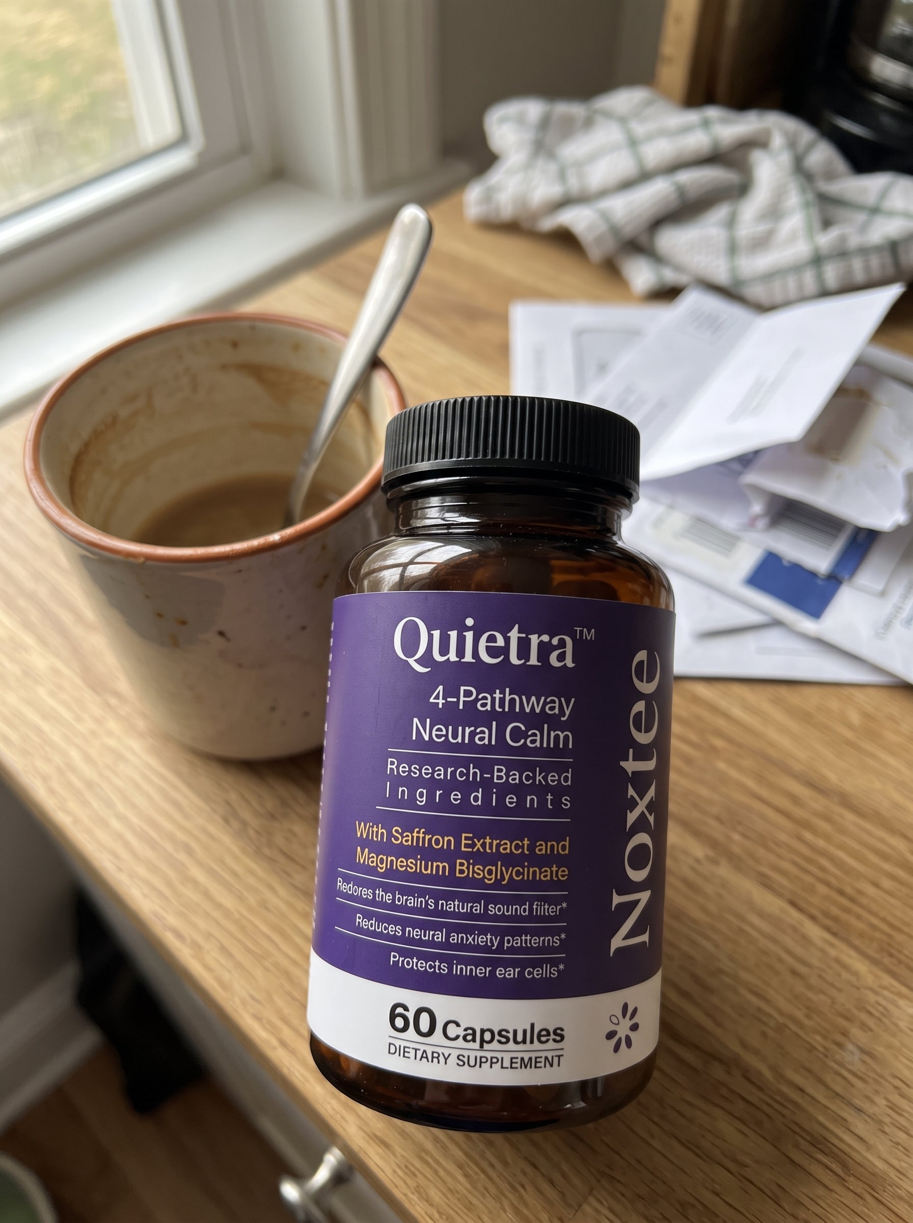 Noxtee bottle on a quiet breakfast table beside coffee