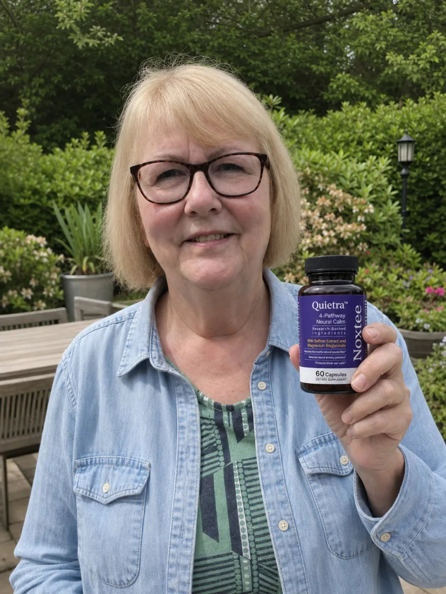 Woman holding a bottle of Quietra in her garden