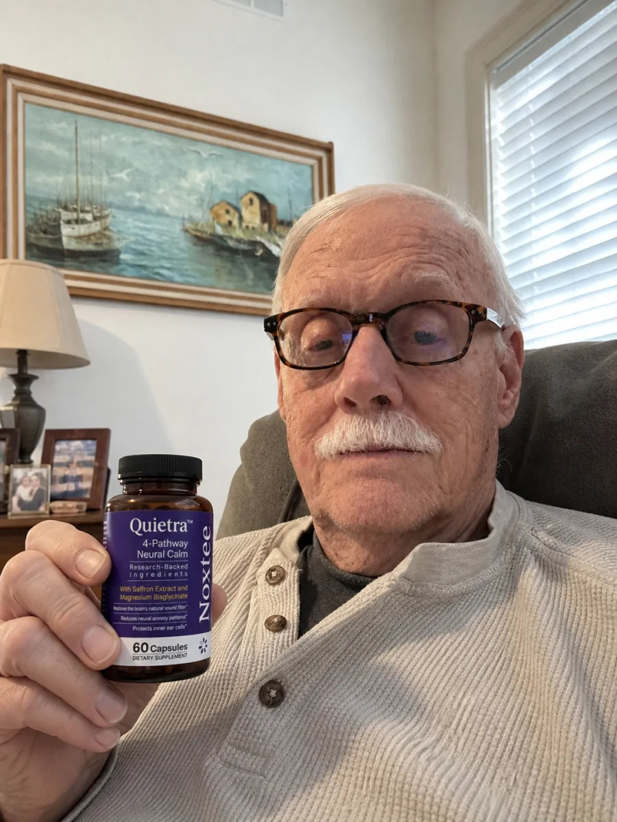 Man holding a bottle of Quietra in his living room