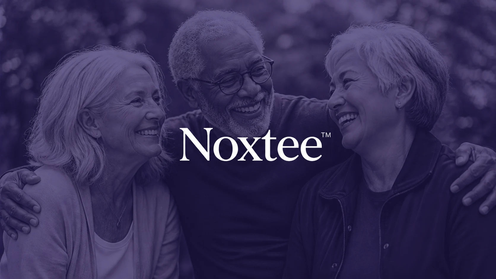 Three older adults smiling together in a purple Noxtee brand portrait